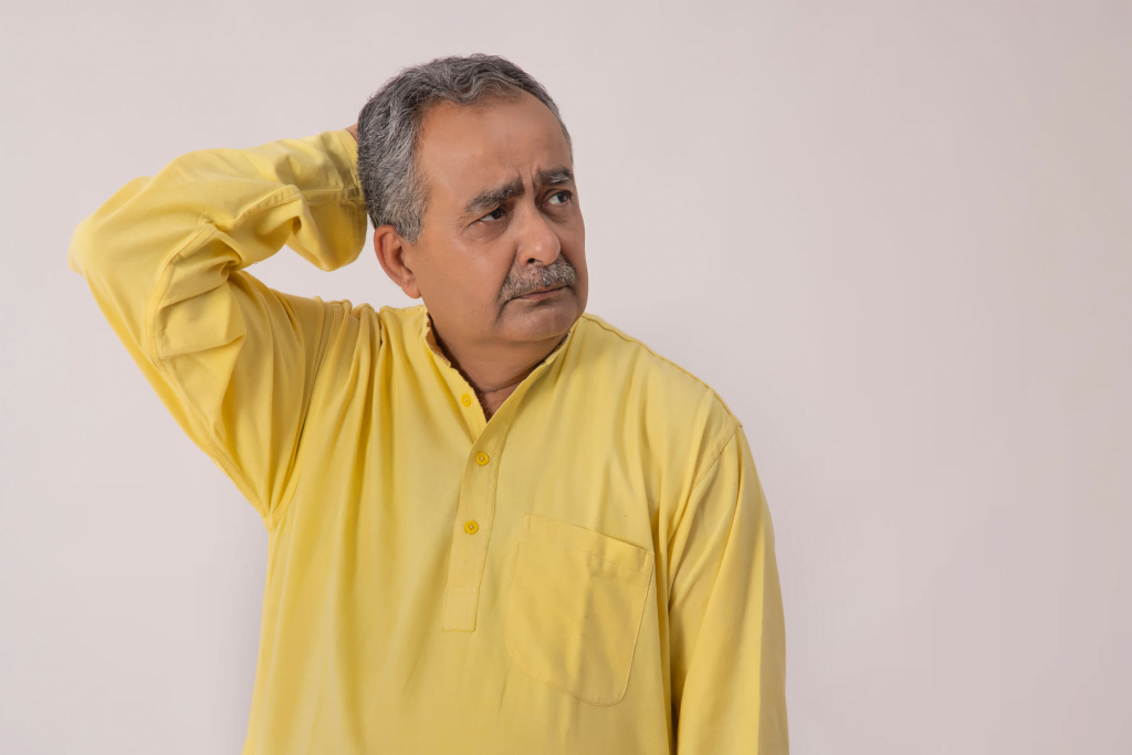 A man in a yellow kurta appears to have forgotten something.