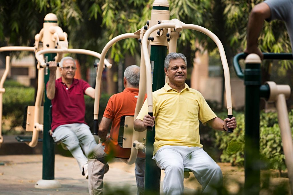 Elderly men training in an outdoor gym, showcasing the significance of senior fitness for longevity